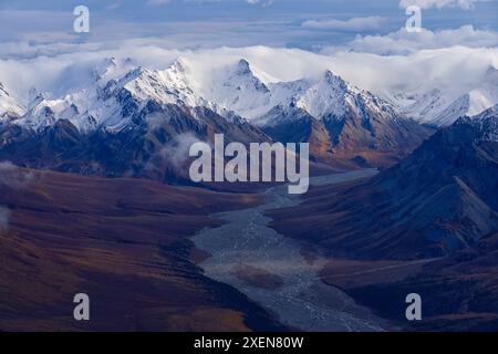 Aus der Vogelperspektive auf die herbstfarbenen Hänge und die majestätischen, schneebedeckten Berge des Kluane National Park, aufgenommen während des Übergangs zwischen Herbst und... Stockfoto