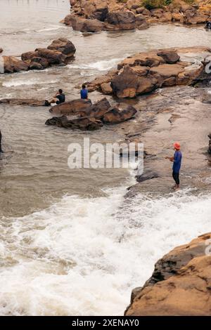 Junge Männer fischen und genießen die Aussicht am Tad Lo Wasserfall in Laos; Beng, Provinz Salavan, Laos Stockfoto