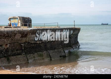 Margate, Großbritannien. Juni 2024. Ein junges Paar sitzt am Mosaik des Margate Lido. Ein Graffiti ist auf der Seite. Es heißt 'Schwimmbad', aber die hervorgehobenen Buchstaben sagen nur 'SCHWIMMEN IN KO' wegen der hohen Abwasserverschmutzung in den britischen Gewässern. Graffiti bezieht sich auf die Abwasserverschmutzung, die durch den südlichen Wasserskandal verursacht wurde. Laut der Umweltbehörde hat das südliche Wasser im vergangenen Jahr über 317000 Stunden Rohabwasser ins Meer geleitet. (Foto: Krisztian Elek/SOPA Images/SIPA USA) Credit: SIPA USA/Alamy Live News Stockfoto