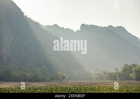 Sonnenlicht über den Karstformationen durch den Nebel auf die Landschaft in Laos; Provinz Khammouane, Laos Stockfoto