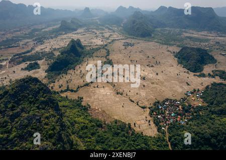 Landschaft mit Ackerland, Karstformationen und einem Dorf im Gebiet Vang Vieng in Laos; Provinz Vientiane, Laos Stockfoto