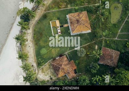 Immobilien mit Dächern und Palmen in Mallasoro, Süd-Sulawesi, Indonesien; Mallasoro, Bangkala, Jeneponto Regency, Süd-Sulawesi, Indonesien Stockfoto