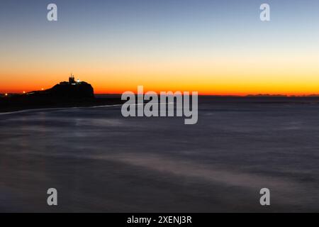 Nobbys Leuchtturm und Strand bei Sonnenaufgang. Dieser Leuchtturm ist eines der berühmtesten Wahrzeichen von Newcastle Stockfoto