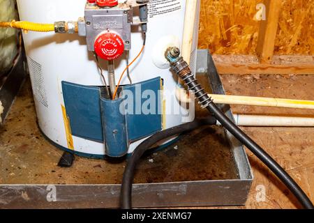 Schlauch am Ablass des Warmwasserbereiters angeschlossen, Wasser in Auffangwanne Stockfoto