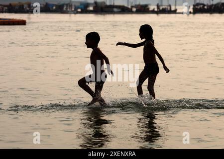 Kinder kühlen sich in Sangam (Zusammenfluss der Flüsse Ganges, Yamuna und mythischen Saraswati) an heißen Sommertagen in Prayagraj, Indien. Stockfoto