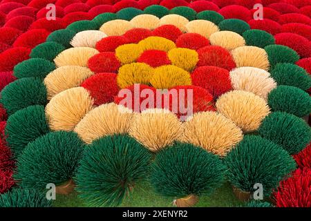 Lebendiger Weihrauch wird im Juni in Quang Phu Cau, Ung Hoa, Nordvietnam, Asien, zum Trocknen in der Sonne gelegt - rote, gelbe, grüne Weihrauchstäbchen Stockfoto