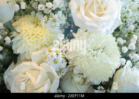 Nahaufnahme eines Blumenstraußes mit weißen Rosen, Chrysanthemen und Babyblüten. Stockfoto