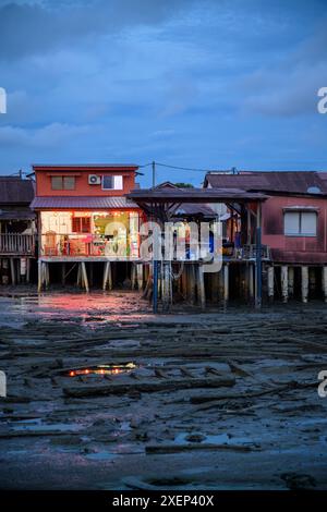 Rustikale Häuser auf Stelzen am Chew Jetty vom Tan Jetty in der Abenddämmerung, George Town, Penang, Malaysia Stockfoto