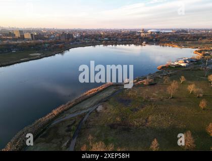 nyc Skyline bei Sonnenuntergang (Luftdrohne aus weitem Abstand in Königinnen) Corona Flush WiWiWiWiWiWiesen Park mit Wiesensee im Vordergrund (untergehende Sonne Stockfoto