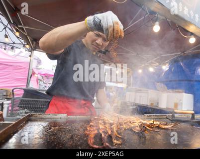 Markham, Kanada. Juni 2024. Ein Koch grillt Tintenfische während der Veranstaltung „Taste of Asia“ 2024 in Markham, Kanada, am 28. Juni 2024. Das dreitägige Festival begann hier am Freitag. Quelle: Zou Zheng/Xinhua/Alamy Live News Stockfoto