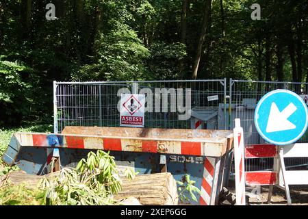 Niederländische Baustelle mit Asbestlagerung (asbest geen toegang - asbest kein Zugang) Abfallbehälter, Überspringen, Schild. Sommer, Juni, Niederlande. Stockfoto