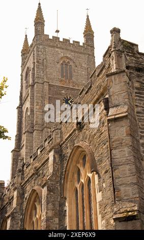 St Fimbarrus Church, Fowey, Cornwall, Großbritannien - Uhrturm und Teil der Seite der Kirche. Die Kirche St. Fimbarrus ist eine anglikanische Pfarrkirche in Fowey, C. Stockfoto