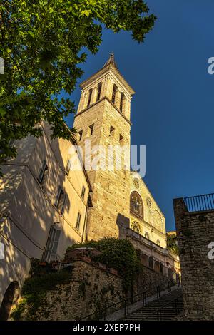 Blick von unten auf den Glockenturm und die von der untergehenden Sonne beleuchtete Fassade der Kathedrale von Spoleto, der Kathedrale von Santa Maria Assunta. Umbrien Stockfoto