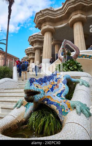 Salamander-Skulptur (auch bekannt als „DRAC“ oder „Drache“) mit Hypostyle-Halle im Hintergrund. Park Güell von Antonio Gaudí. Barcelona. Katalonien. Spanien. Stockfoto