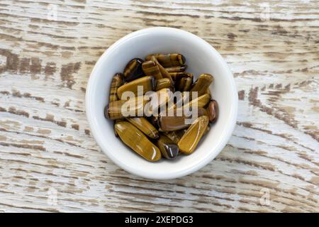 Naturmineralischer Edelstein Tiger's Eye Tigers Eye, Tiger Eye Edelstein als schöner Hintergrund Nahaufnahme von oben Stockfoto