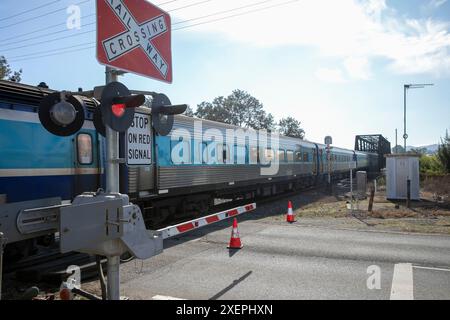 Australian Railway Train, Paterson Village Railway Level Crossing gesperrt, um den NSW-Zug passieren zu lassen, Paterson, NSW, Australien, 2024 Stockfoto