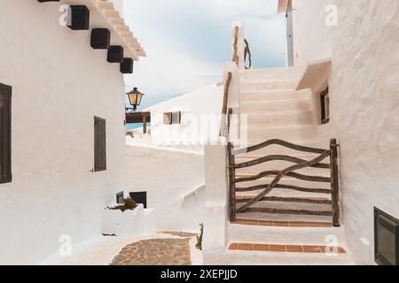 Wunderschönes Spanien. Die charmante Stadt Binibeca auf Menorca. Weiße Wände von Häusern mit Holzelementen Stockfoto