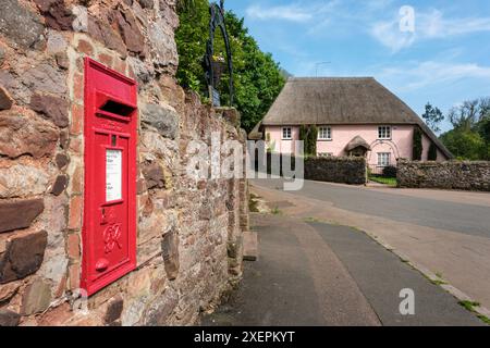 Ein Briefkasten und ein reetgedecktes Häuschen in Cockington Village, Torquay, Devon Stockfoto