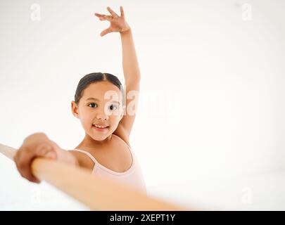 Ballett, Mädchen und Tanzbarre im Porträt, anmutig und erste Position für Balance in der darstellenden Kunst. Tänzer, selbstbewusst und Technik mit Schüler Stockfoto