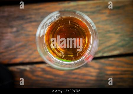 Ein Glas leichtes Bier wird von oben betrachtet und zeigt das erfrischende Getränk mit seinem bernsteinfarbenen Farbton und Bläschen. Diese Top-down-Perspektive erfasst den Stockfoto