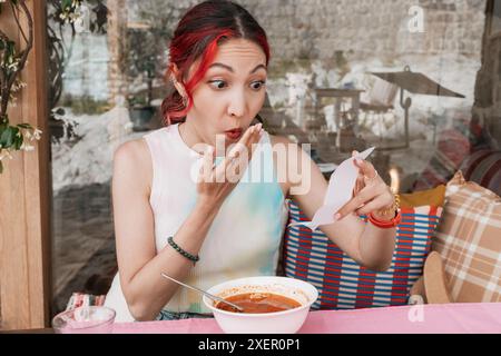 Schockierte Frau in einem Restaurant, die mit einer unerwartet teuren Rechnung konfrontiert wurde. Stockfoto