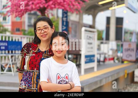 Porträt Touristen Asiatische Mutter und Tochter auf dem Bangsaen Fischmarkt in Chonburi, Thailand. Japanisches Bahnhofsthema für Touristen in Bangsaen Fish Mark Stockfoto