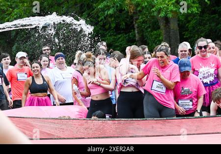 Brighton UK 29 Juni 2024 - Tausende nehmen an einem warmen sonnigen Tag im Stanmer Park Brighton am Cancer Research UK Pretty Muddy Race for Life Teil. Teilnehmer, die von Krebs berührt wurden, finden ihren Weg um den hübschen Muddy Hindernislauf, der etwas mehr als 3 Meilen entfernt ist und hilft, Tausende von Pfund für Cancer Research UK zu sammeln: Credit Simon Dack / Alamy Live News Stockfoto