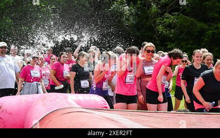 Brighton UK 29 Juni 2024 - Tausende nehmen an einem warmen sonnigen Tag im Stanmer Park Brighton am Cancer Research UK Pretty Muddy Race for Life Teil. Teilnehmer, die von Krebs berührt wurden, finden ihren Weg um den hübschen Muddy Hindernislauf, der etwas mehr als 3 Meilen entfernt ist und hilft, Tausende von Pfund für Cancer Research UK zu sammeln: Credit Simon Dack / Alamy Live News Stockfoto