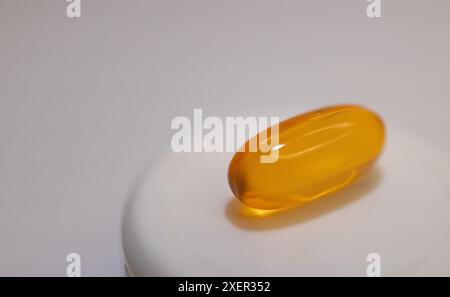 Nahaufnahme einer Vitaminweichkapsel auf hellem Hintergrund. Stockfoto