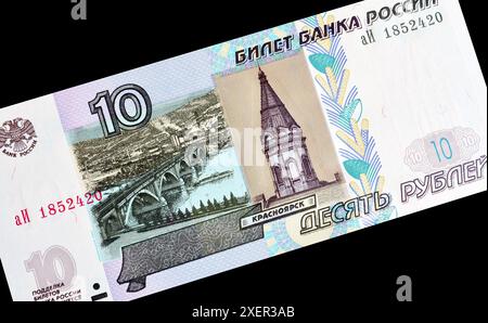 10-Rubel-Banknote, gedruckt von Russland, die die Brücke über den Jenisei-Fluss in Krasnojarsk zeigt Stockfoto