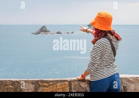 Frau im Urlaub am Aussichtspunkt der Insel Saint Nedjelja, Montenegro, mit Blick auf die natürliche Landschaft und das klare blaue Wasser Stockfoto