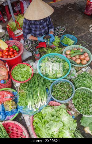 Hoi an, Vietnam - 5. Februar 2024: Obst- und Gemüsehändler mit traditionellen asiatischen konischen Hüten, Hoi an Market, Vietnam Stockfoto