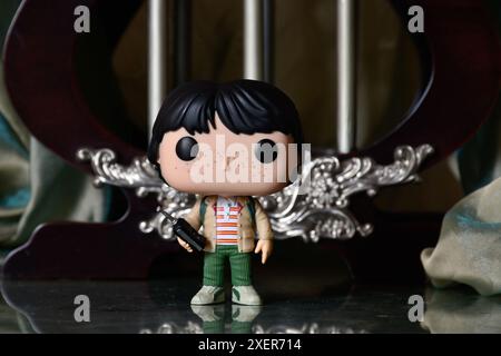 Funko Pop Actionfigur von Mike mit Walkie-Talkie aus der beliebten Horror-TV-Serie Stranger Things. Reflektionsboden, grüner Vorhang, Vintage Palast. Stockfoto