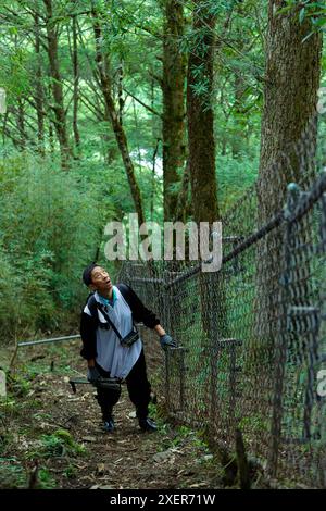 (240629) -- WOLONG, 29. Juni 2024 (Xinhua) -- Mitarbeiter Mu Shijie sucht nach Riesenpandabubs, während er die Wildübungsfelder des Tiantai Berges im Wolong National Nature Reserve in der südwestlichen chinesischen Provinz Sichuan patrouilliert, 24. Juni 2024. In den letzten Jahren hat China durch eine Reihe von Maßnahmen, darunter Wald- und Wildtierschutz sowie den Bau von riesigen Panda-Nationalparks, bedeutende Fortschritte beim Pandaschutz erzielt. Die Population wilder Riesenpandas in China ist von etwa 1.100 in den 1980er Jahren auf fast 1.900 angestiegen. Riesenpanda-Reintroducti Stockfoto