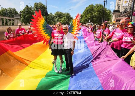 London, Großbritannien. Juni 2024. Der Londoner Bürgermeister Sadiq Khan nimmt in Begleitung seiner Frau an der Parade an der Front Teil und posiert mit Menschen und der Regenbogenfahne. Teilnehmer und Zuschauer haben Spaß auf der Strecke bei der Pride in London 2024 Parade. Die Parade verläuft vom Hype Park entlang Piccadilly nach Whitehall und eine Party am Trafalgar Square. Sie zelebriert Vielfalt und die LGBT-Community. Quelle: Imageplotter/Alamy Live News Stockfoto