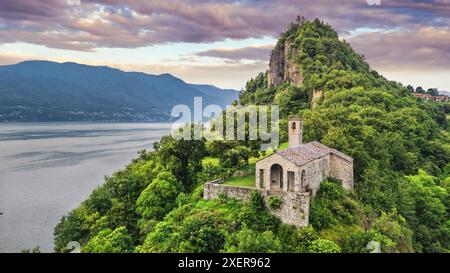 Luftaufnahme der Rocca von Calde und des Lago Maggiore im Hintergrund während Sonnenuntergang, am Sommertag, Castelveccana, Italien Stockfoto
