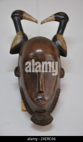 Wunderschön geschnitzte, traditionelle Holzmaske, Nationalmuseum, Lome, Togo - menschliches Gesicht mit zwei Enten auf dem Kopf Stockfoto