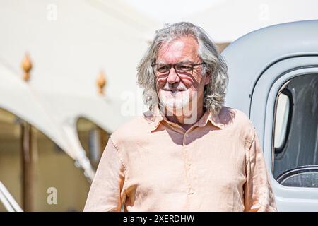 BROADCHALKE, SALISBURY, WILTSHIRE, Vereinigtes Königreich, 29. Juni, 2024, The Grand Tour und ehemaliger Top Gear Moderator, Fernsehpersönlichkeit James May, der vor einem Chevrolet in der Sonne stand, während er das Chalke History Festival besuchte, um seinen Vortrag mit dem Titel „The Car: did we get it wrong?“ zu halten. Mit James Holland. John Rose/Alamy Live News Stockfoto