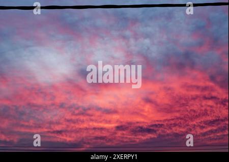 Feuriger Sonnenuntergang in Portugal mit leuchtenden Rot- und Violettönen, die den Himmel bemalen Stockfoto