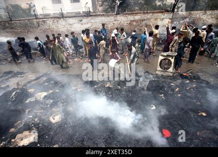 Ansicht des Standorts nach Ausbruch eines Brandes in den Geschäften, da die Feuerwehr am Samstag, den 29. Juni 2024, in Nothia, in Peshawar, mit Lösch- und Rettungsaktionen beschäftigt ist. In den Geschäften in der Nähe der Eisenbahnstrecke Gulberg Nothia in Peshawar, Pakistan, brach ein massives Feuer aus. Die Flamme, die in einer Ansammlung von meist gebrauchten Geschäften begann, die auf die Eisenbahnlinien eindrangen, breitete sich schnell auf angrenzende Wohngebiete aus und verursachte eine weitverbreitete Panik und Zerstörung. Stockfoto