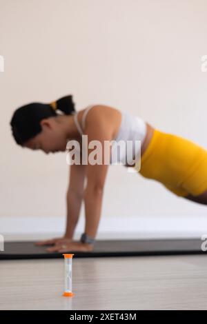 Nahaufnahme von Sanduhr und verschwommener Frau in Plankenstellung Stockfoto