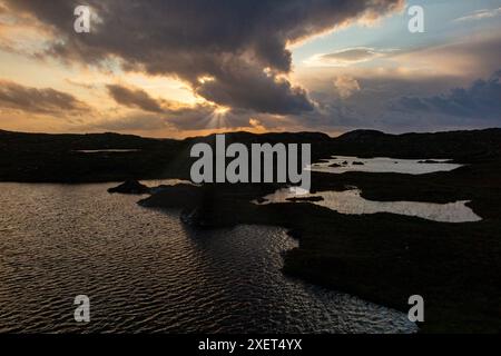 Ein atemberaubender Sonnenuntergang über den Lochs von Assynt in Nordschottland Stockfoto