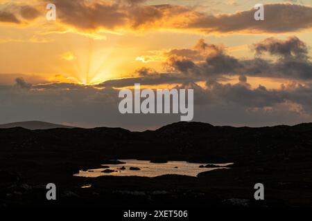 Ein atemberaubender Sonnenuntergang über den Lochs von Assynt in Nordschottland Stockfoto