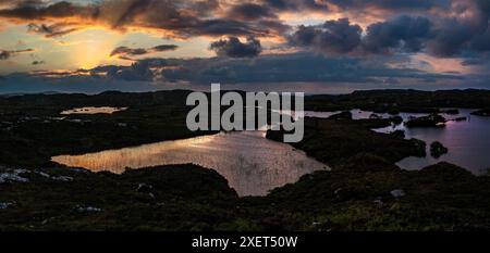 Ein atemberaubender Sonnenuntergang über den Lochs von Assynt in Nordschottland Stockfoto