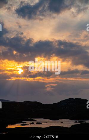 Ein atemberaubender Sonnenuntergang über den Lochs von Assynt in Nordschottland Stockfoto