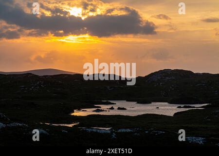 Ein atemberaubender Sonnenuntergang über den Lochs von Assynt in Nordschottland Stockfoto