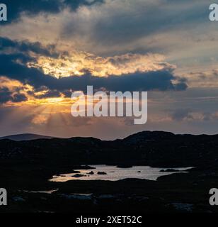 Ein atemberaubender Sonnenuntergang über den Lochs von Assynt in Nordschottland Stockfoto