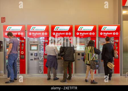 Fahrgäste, die die automatischen Automaten für den Indoor-Zug Trenitalia nutzen, um ihre Bahnfahrkarten zu kaufen Stockfoto