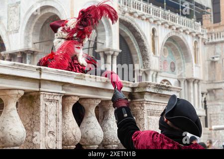 Karneval in Venedig, eine junge Frau in historischer Tracht, die von einem Nibleman in der Basilika San Marco, Venedig, Veneto, Italien verführt wird Stockfoto