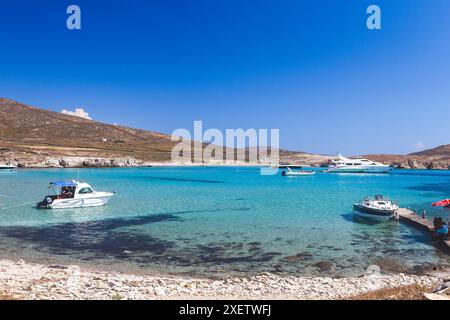 Die malerische Bucht von Rheneia, Griechenland, wo kristallklares türkisfarbenes Wasser auf die goldene Küste trifft, perfekt für einen entspannenden Tag am Meer. Stockfoto